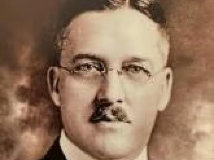 James E. Cutler looks at camera while wearing formal attire
