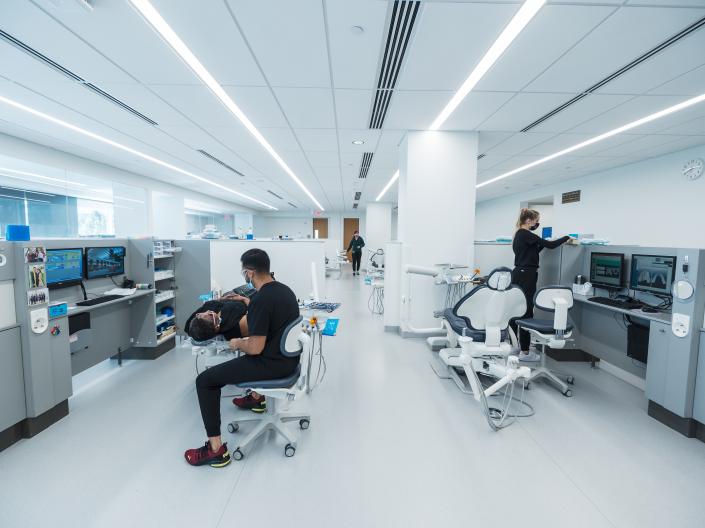 Student dentist treating patient in campus dental clinic