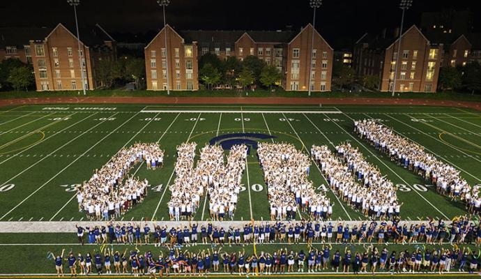 Students for the letters CWRU on the football field