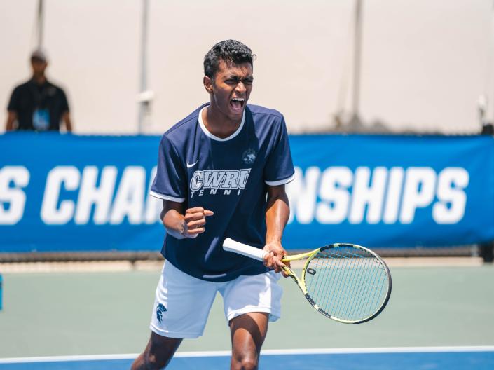A tennis player celebrates on the tennis court.