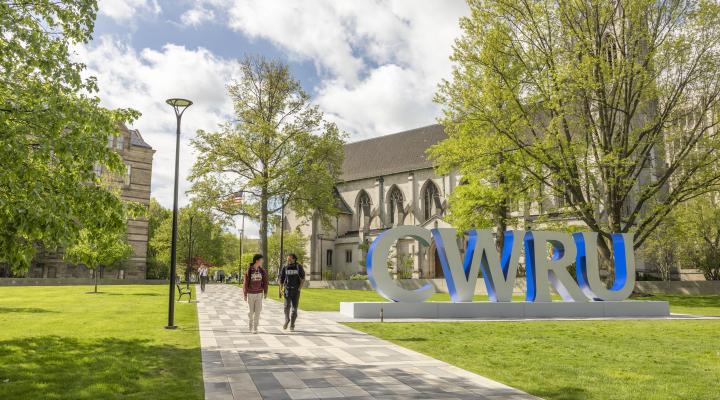 Two student on binary walkway with large CWRU letters.