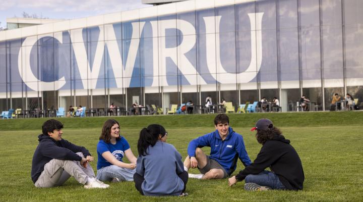 Students sitting in the grass on Frieberger Field