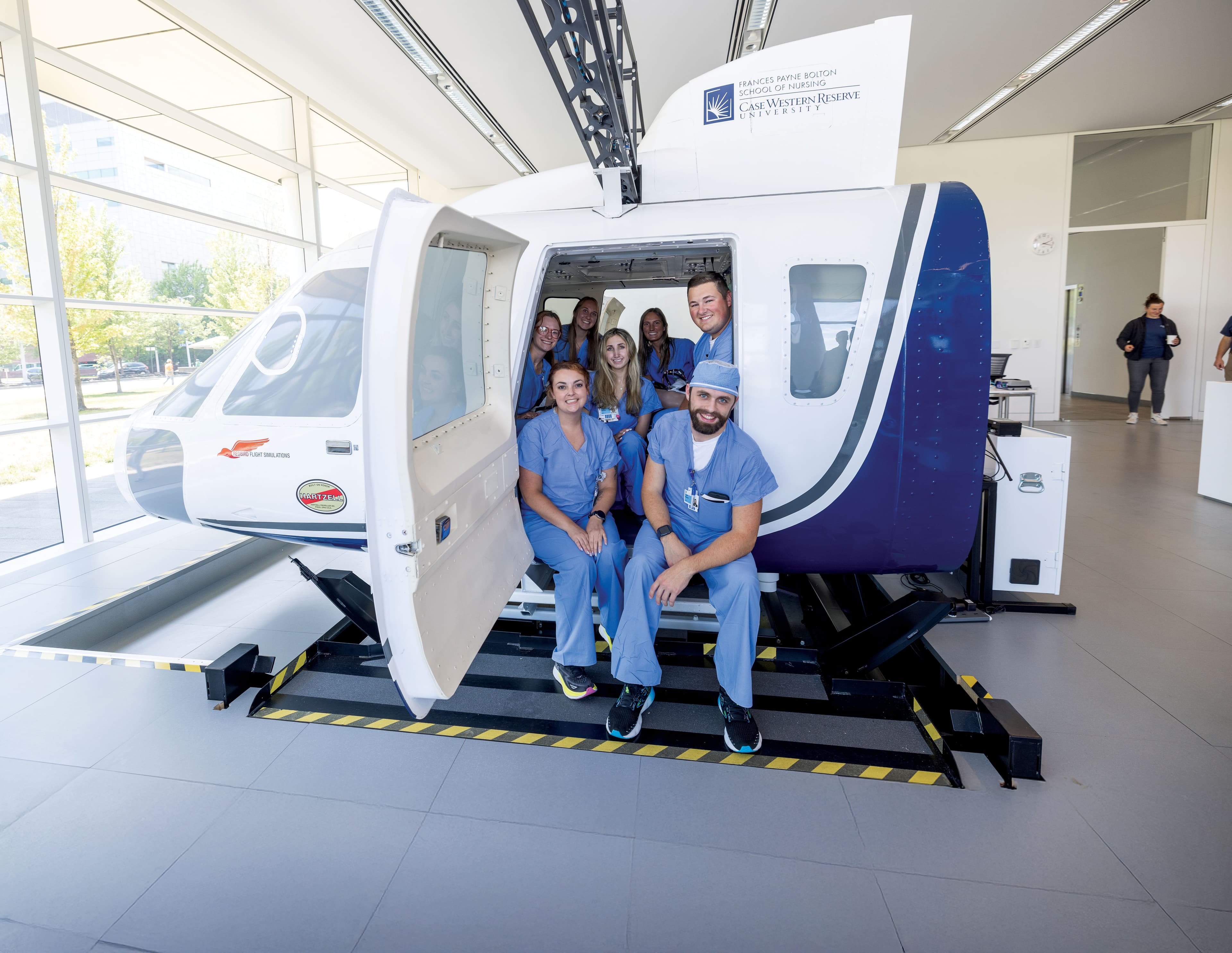 Medical professionals in blue scrubs standing at a medical transport helicopter