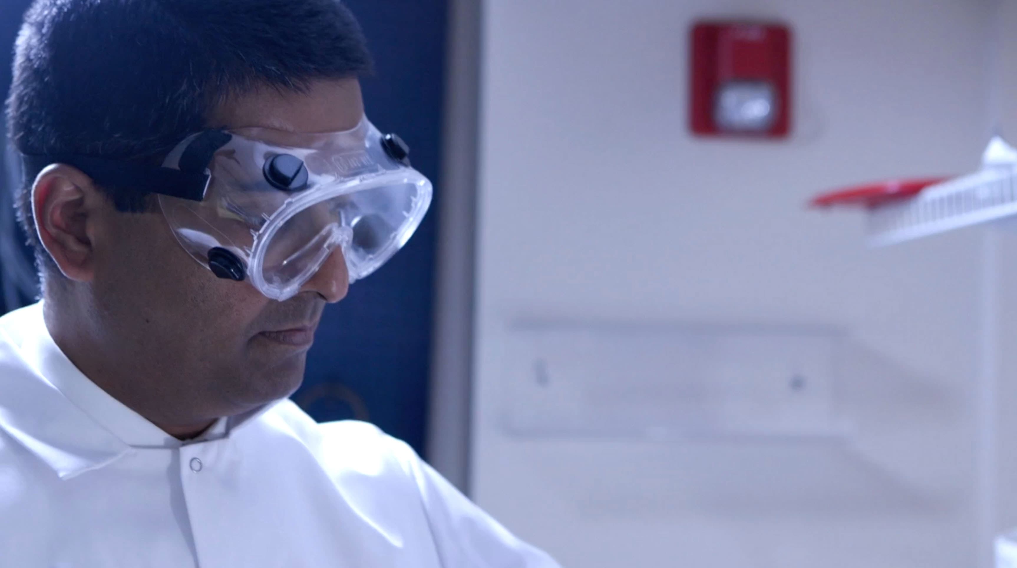 Students in lab coats and safety goggles working together in a laboratory