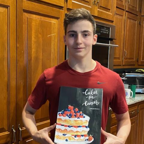Chase Sloan holding Cakes for Cancer cookbook