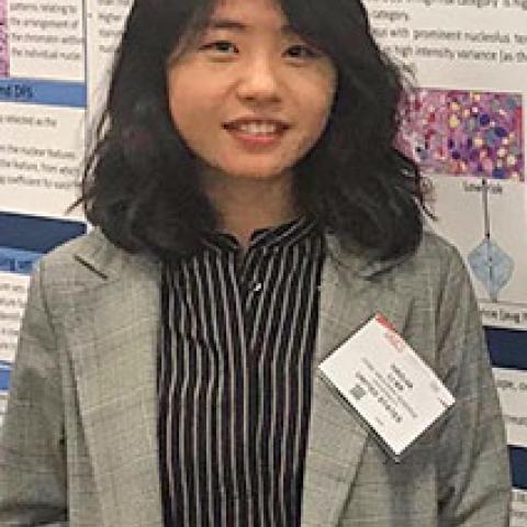 Portrait of Haojia Li standing in front of academic poster