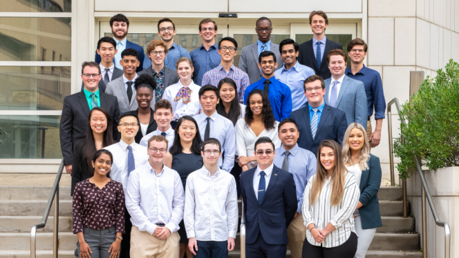 Group of smiling undergraduates on the front steps of the Wolstein Research Building