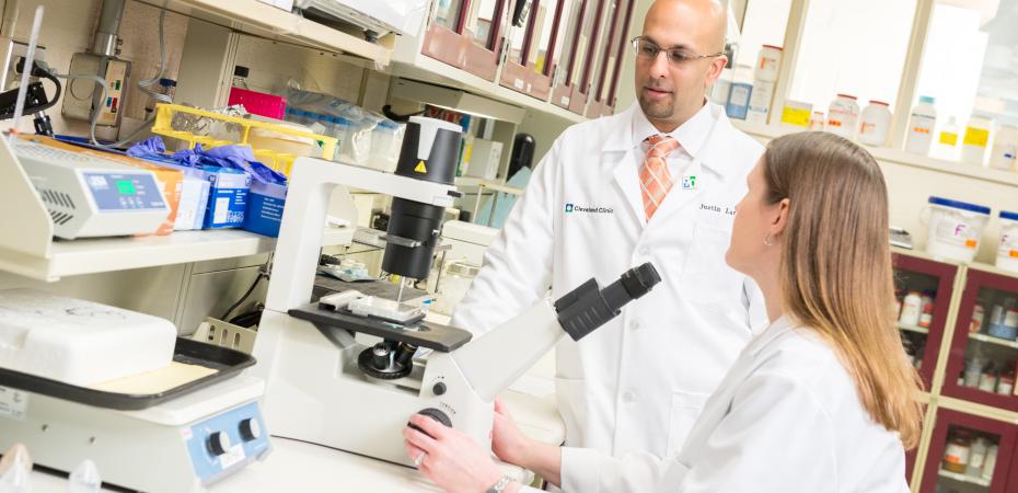 Mentor and mentee in lab in front of microscope
