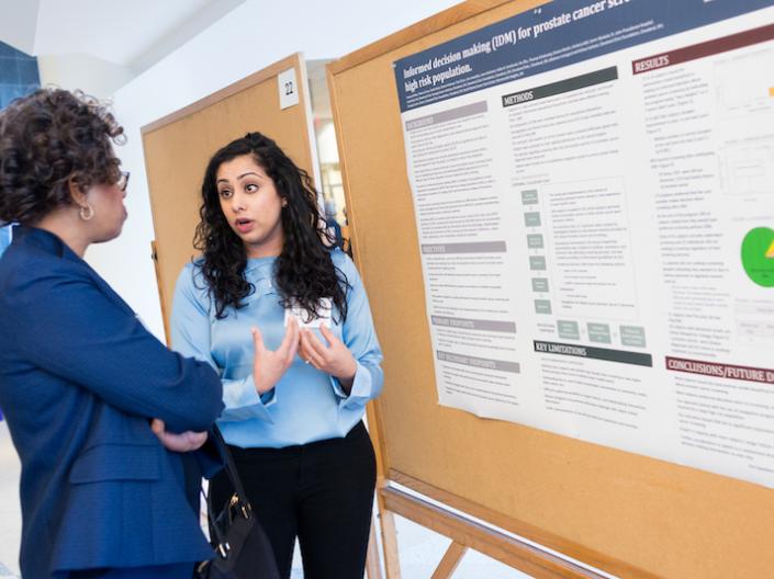Image of an attendee presenting their research poster at the 2018 Cancer Disparities Symposium