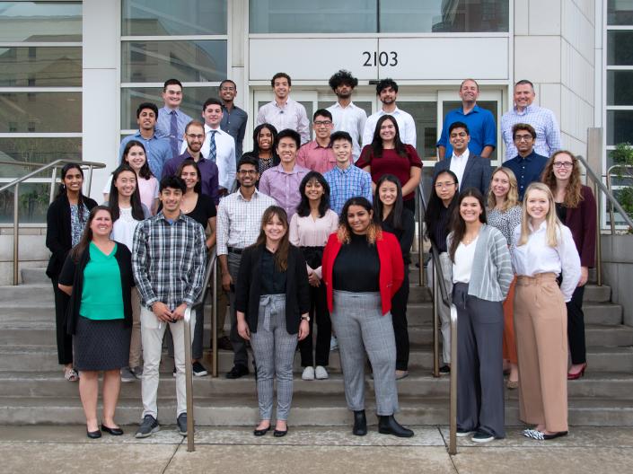 Students gathered for a group photo on the stairs of the Wolstein Research Building with program staff all smiling.