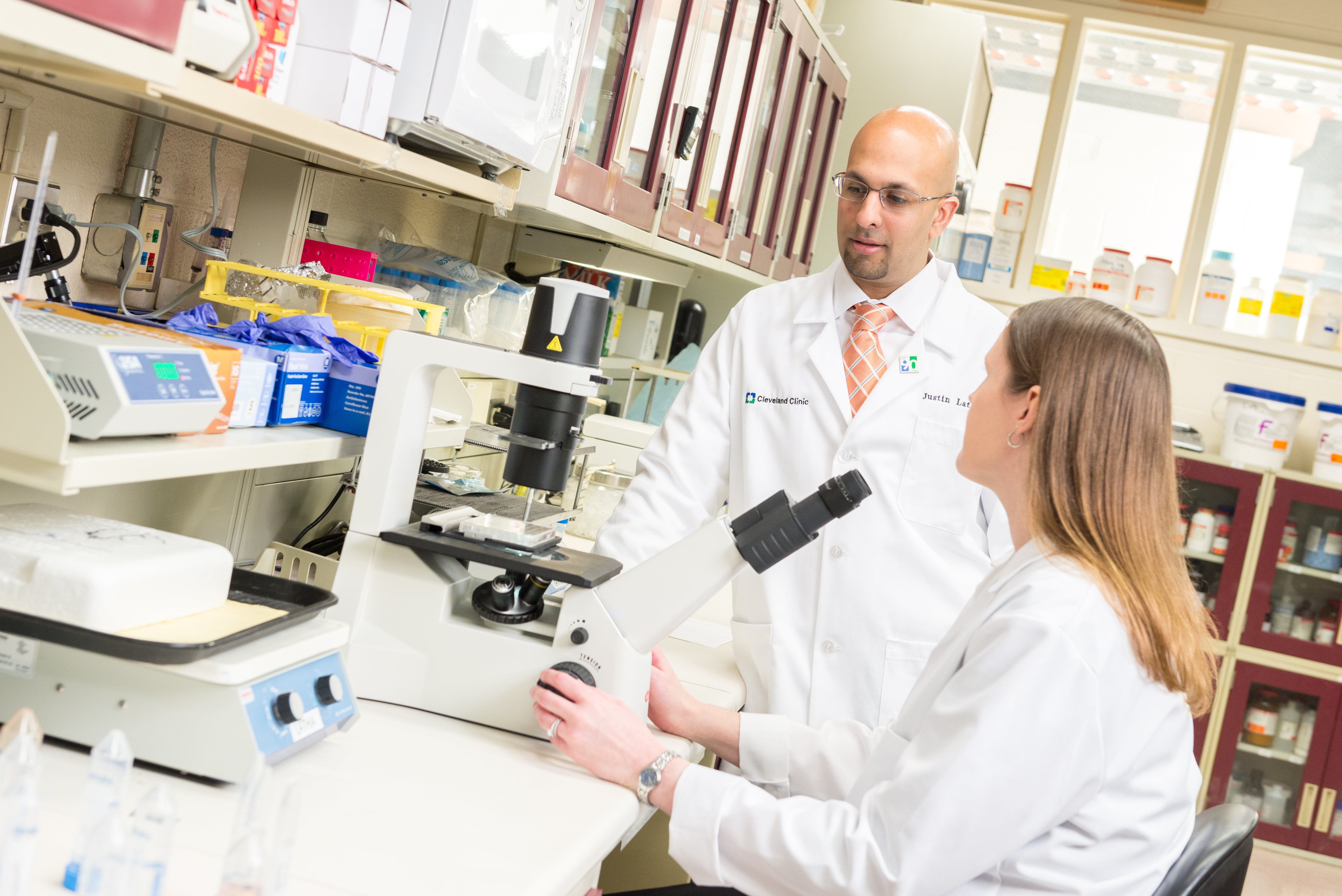 Mentor and mentee in lab in front of microscope