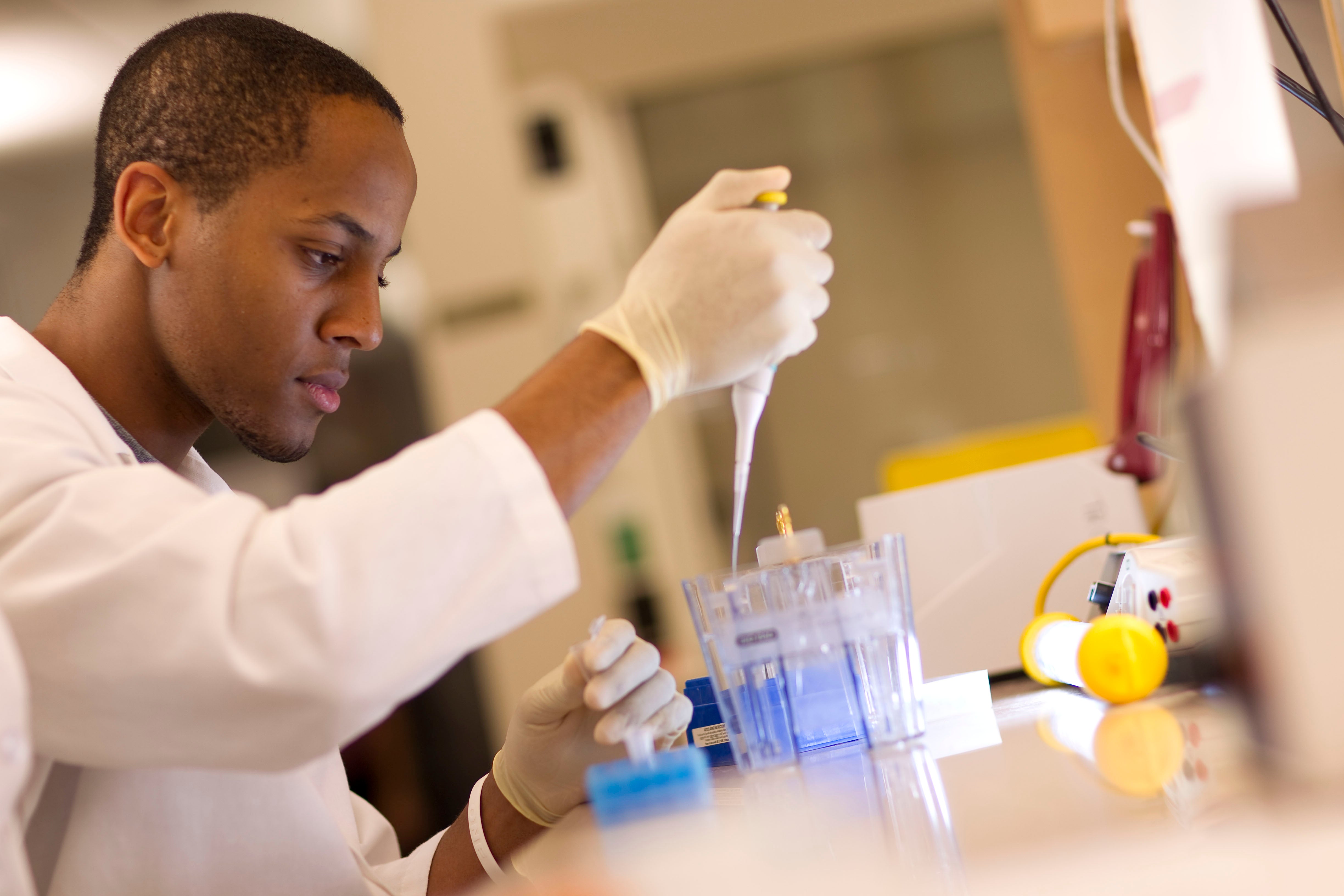 Man in lab pipetting