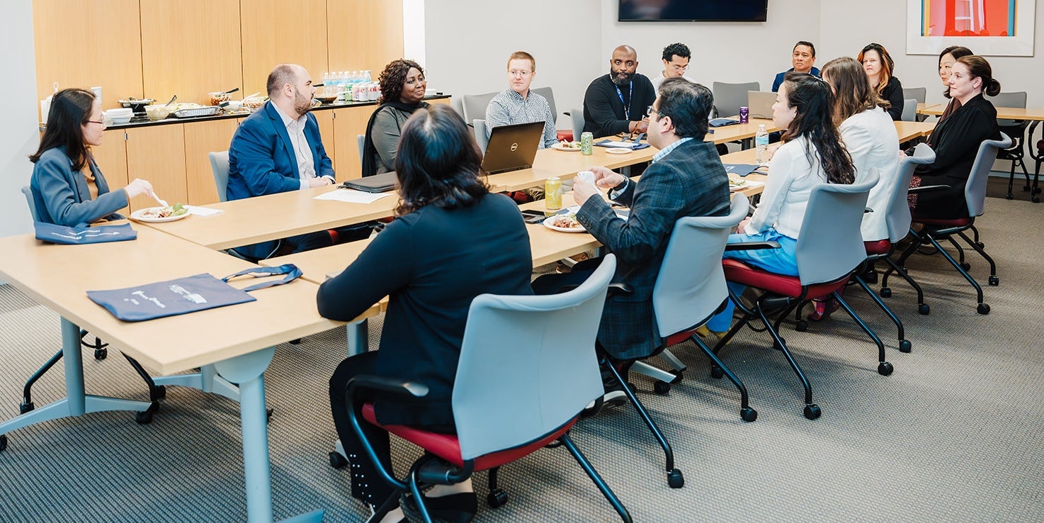 ELP participants conferring around a table in a conference room