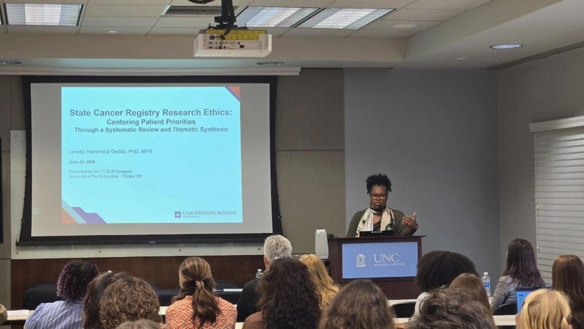 Lynette Hammond Gerido, PhD, MPH, presents "State Cancer Registry Research Ethics: Centering Patient Priorities" during a research presentation at the UNC Lineberger Comprehensive Cancer Center as attendees watch from the audience.