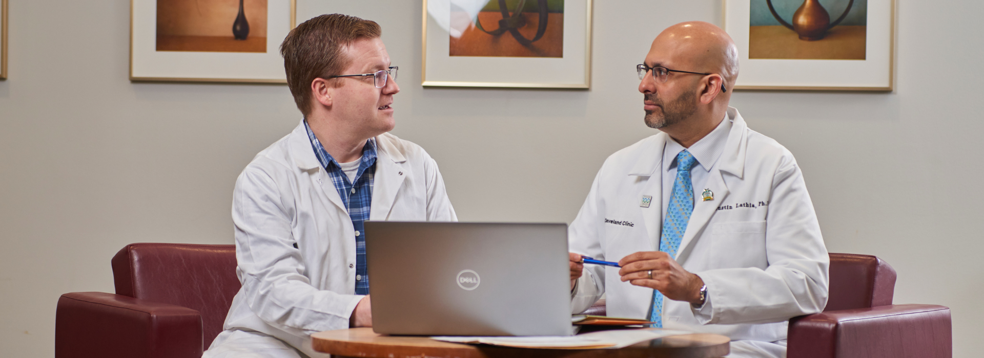 2 doctors sitting in conversation looking at a laptop