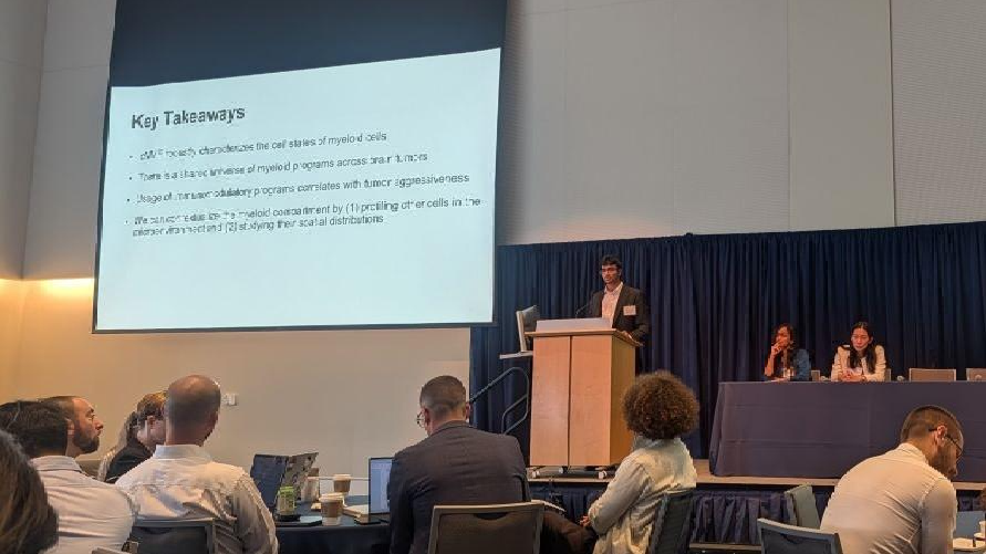 Presenter speaks at the Cellular Plasticity and Tumor Ecosystem Conference as attendees listen and view a “Key Takeaways” slide.