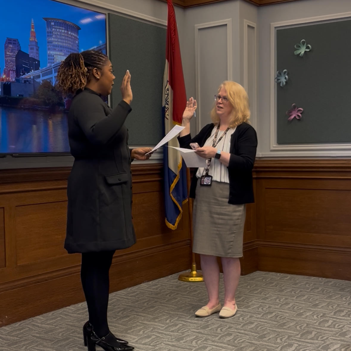 Sydney Evans is sworn in as a commissioner for the Cleveland Commission on Black Women and Girls, raising her right hand during the ceremony at Cleveland City Hall.
