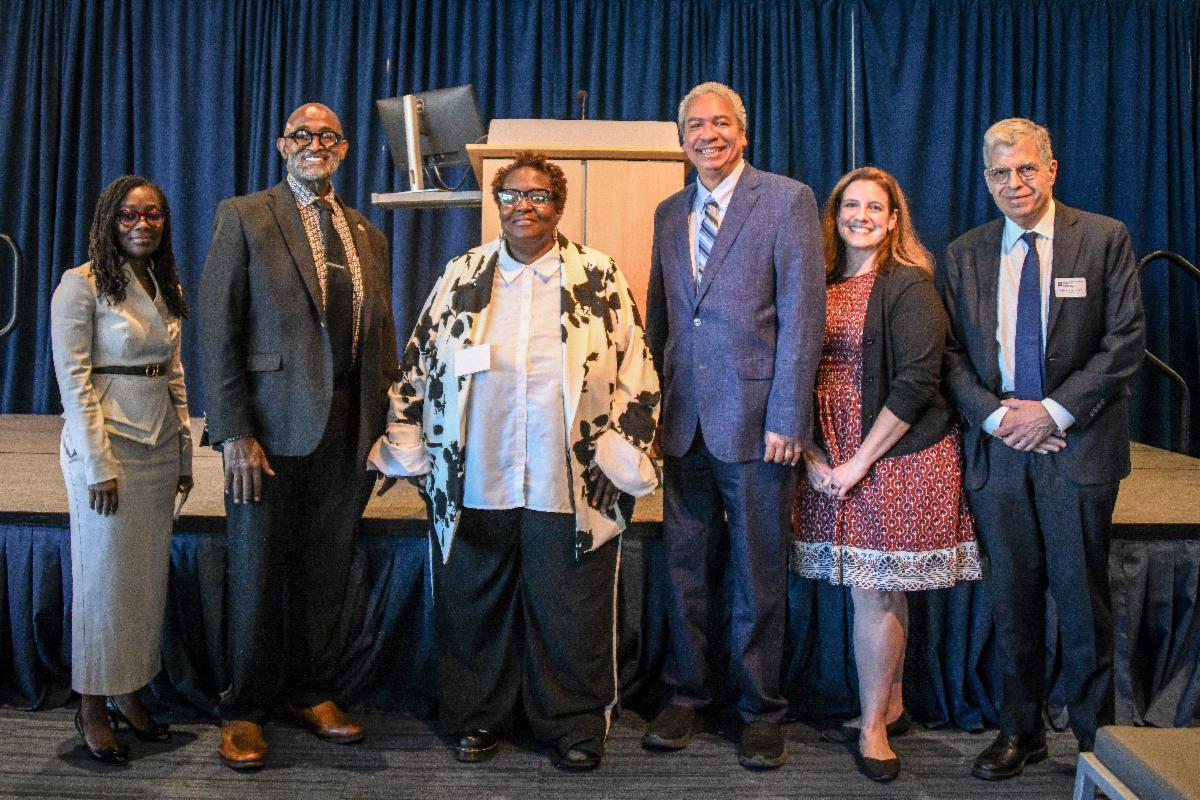 **ADA alt text:**   Six attendees pose together on stage during the Case Comprehensive Cancer Center Annual Scientific Retreat.