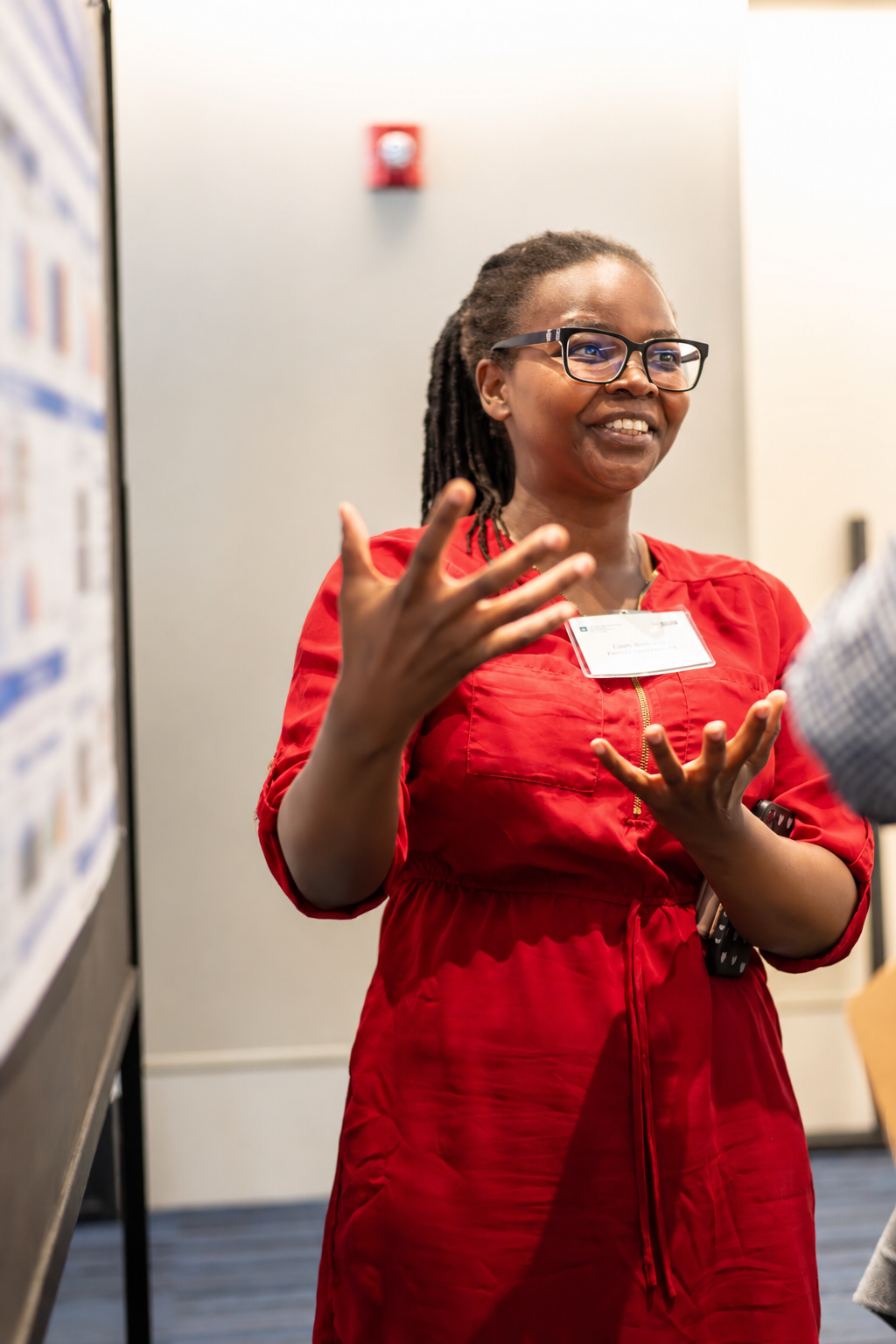A researcher gestures while discussing her scientific poster with an attendee during the Case Comprehensive Cancer Center Annual Scientific Retreat.