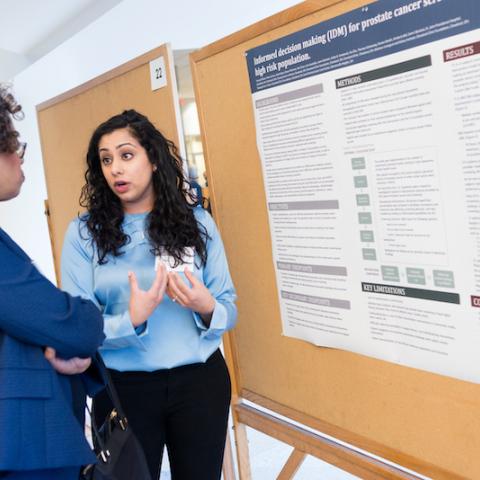 Image of an attendee presenting their research poster at the 2018 Cancer Disparities Symposium