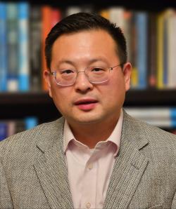 Portrait of Sichun Yang wearing a gray blazer with light pink shirt.