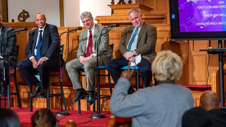 three people sitting on a stage