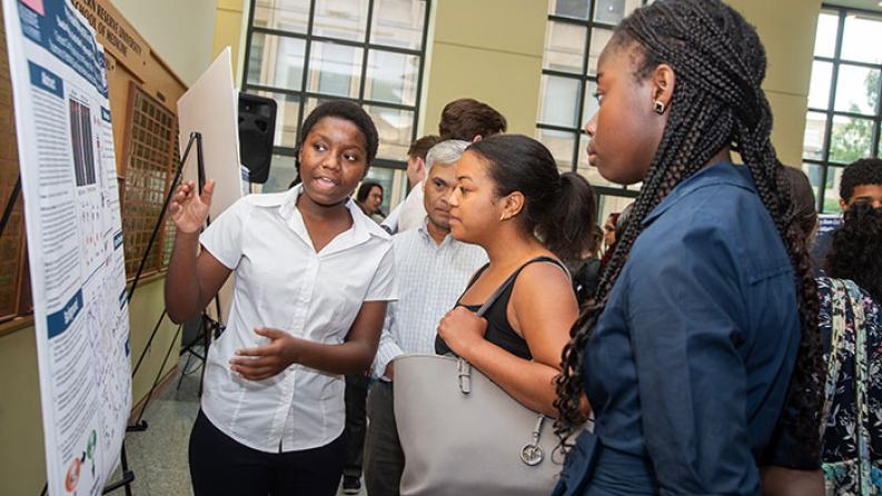 three people talking in front of a poster