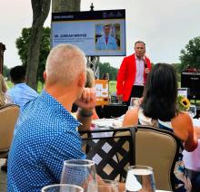 Jordan Winter, MD, is recognized as a 2026 honoree at an American Cancer Society event, with his honoree profile displayed on a screen behind the stage.