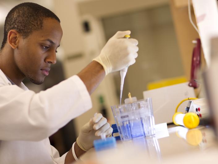 Man in lab pipetting