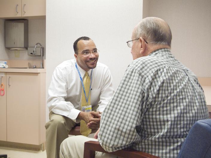 black male doctor talking to white male patient
