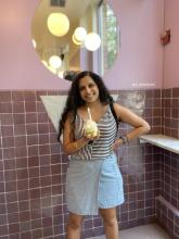 woman with a bowl of ice cream in front of a pink tiled wall