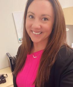 A woman looking and smiling at the camera.