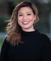 A woman looking and smiling at the camera.