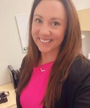 A woman looking and smiling at the camera.