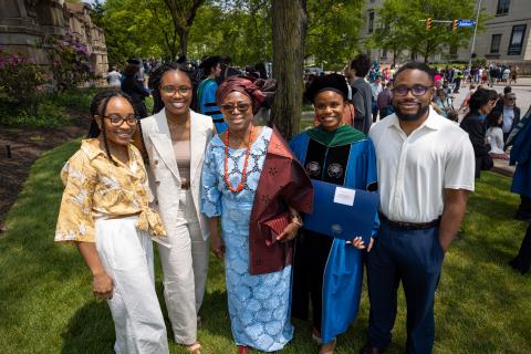 Student posing with their family for a portrait at graduation