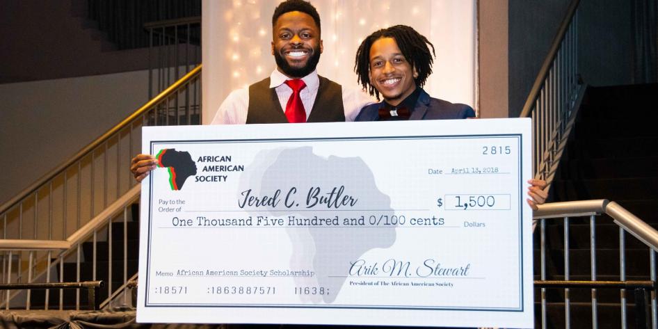 African American Society president Arik Stewart awards scholarship to Jered Butler
