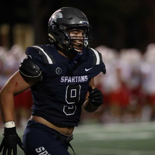  A CWRU student-athlete running across the field in his football uniform.