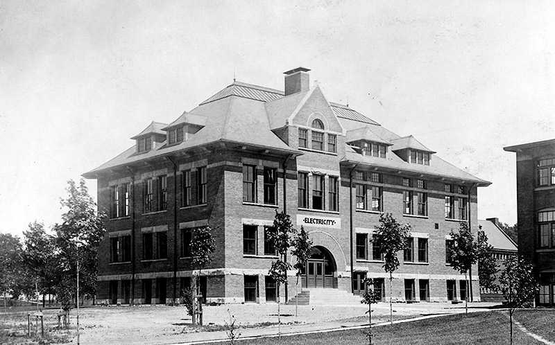 Black and white historical photo of a building on Case Western Reserve’s campus with a sign on it that says “Electricity”