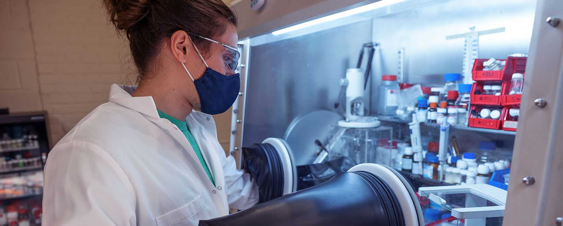 Photo of a Case Western Reserve University student wearing a facemask and goggles, working in a research lab