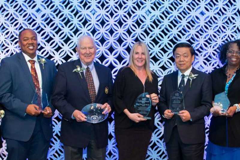 Photo of five Case Western Reserve University alumni holding crystal plaques at an award dinner