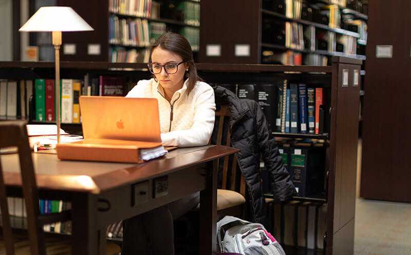 Photo of a Case Western Reserve University student studying at a table in the Judge Ben C. Green Law Library