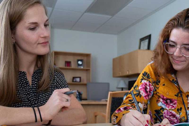 Photo of a Case Western Reserve University student sitting with an advisor, completing paperwork