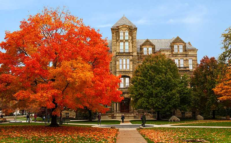 Color photo of Case Western Reserve University’s Adelbert Hall with fall foliage on nearby trees