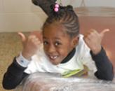 Black girl smiling and giving double thumbs up 