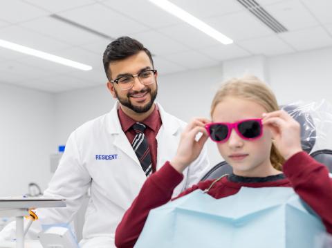 Resident dentist with child patient in dental clinic