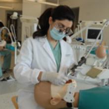 A female dentist student practicing on a dummy