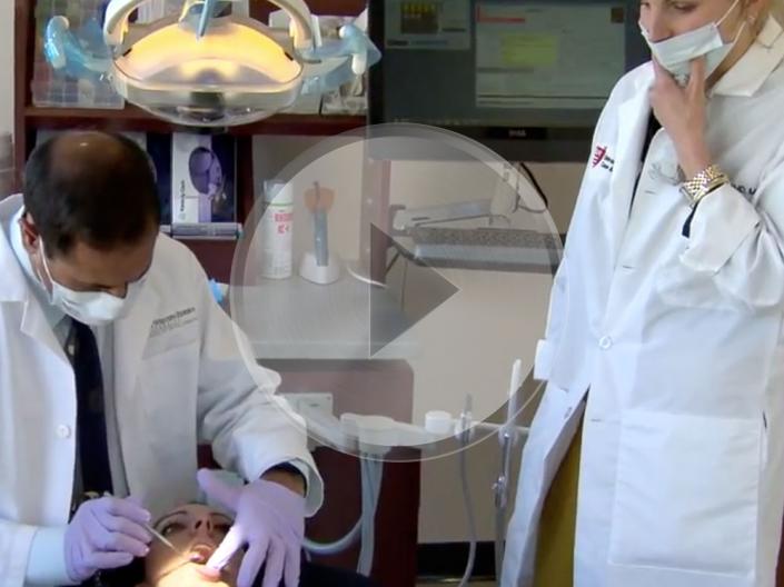 Two dentists examining a patient