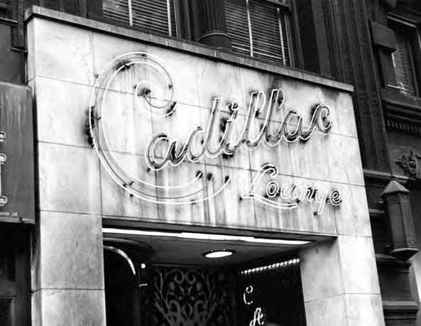 A black and white photo of the facade of a building with a sign that reads "Cadillac Lounge"