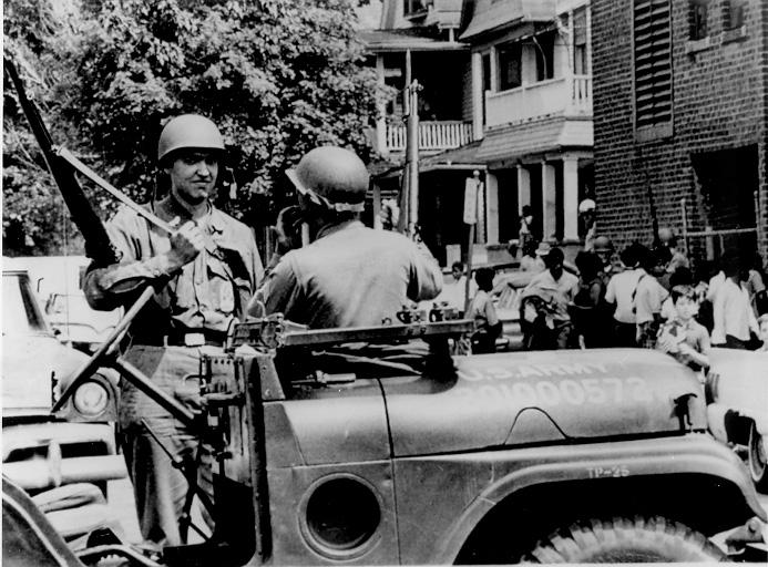 Ohio National Guard soldiers stand near a jeep while on duty  in Cleveland following the Glenville shootout, July 1968. CPL.