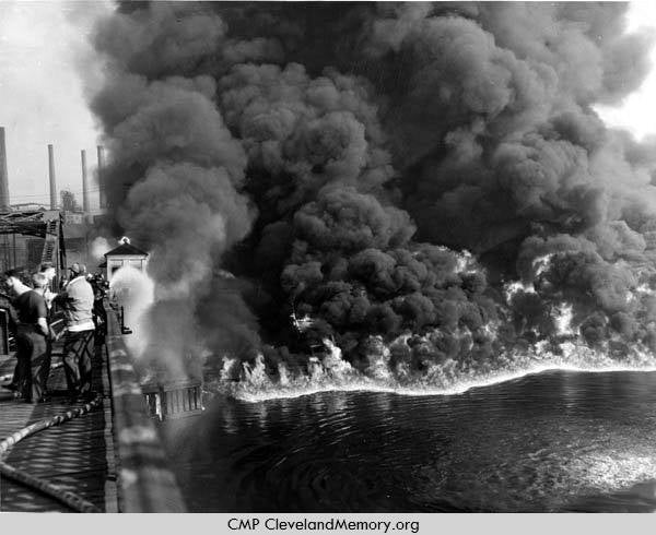1952 Cuyahoga River Fire. Fire and black smoke are rising from the Cuyahoga River with onlookers from a bridge. Cleveland Memory.